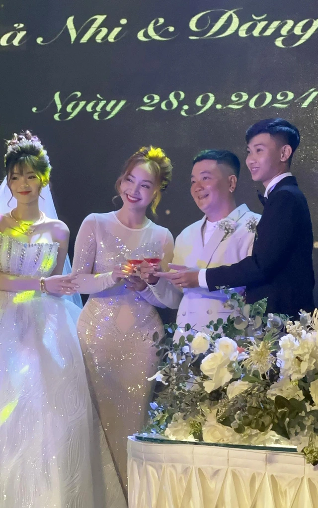 Mẹ cô dâu chọn một bộ đầm ánh kim sang trọng, quý phái, mái tóc búi cao.