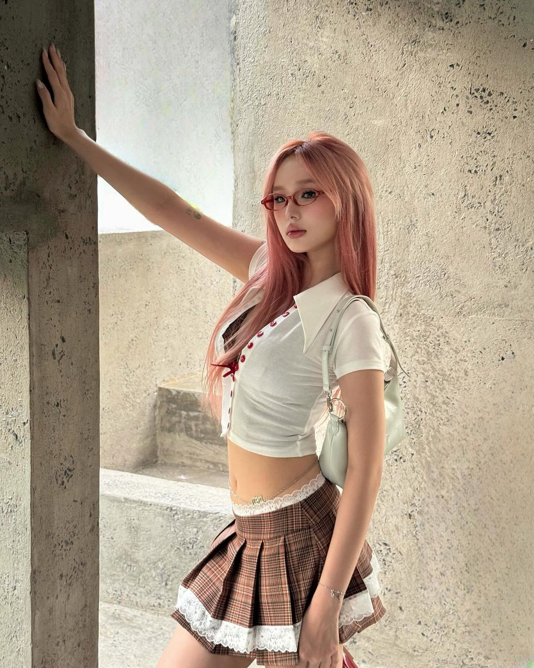 Cô nàng kết hợp gọng kính màu đỏ, trùng với chi tiết cúc áo cùng nội y, tạo nên hơi thở phong cách Y2K mạnh mẽ.