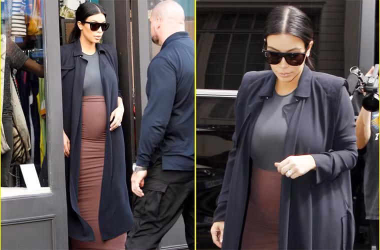 Mặc chân váy màu nâu kết hợp với áo ghi sẫm, khoác thêm chiếc áo dạđen, Kim cùng một vệ sĩ đi mua sắm tại Paris, Pháp.