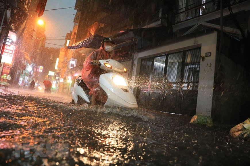 Nhiều tuyến phố ngập nặng khiến nhiều người đi lại khó khăn. (Ảnh: Tuấn Anh/TTXVN)