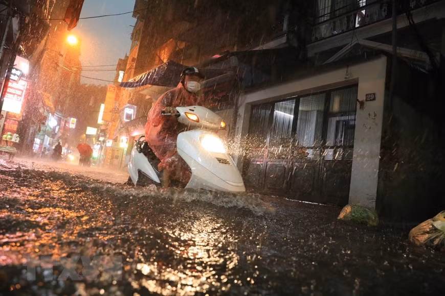 Nhiều tuyến phố ngập nặng khiến nhiều người đi lại khó khăn. (Ảnh: Tuấn Anh/TTXVN)