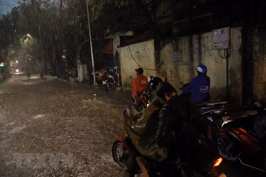 Phố Khương Hạ ngập khiến nhiều người đi lại khó khăn. (Ảnh: Tuấn Anh/TTXVN)