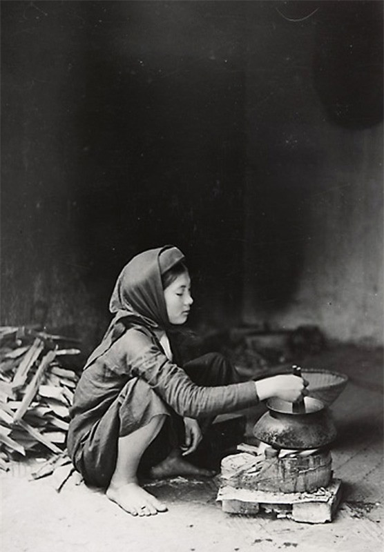 Cảnh phụ nữ nấu cơm.