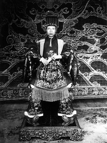 Mỗi nhóm trang phục bao gồm: áo, mũ, đai, xiêm, hốt, hia, hài... được may theo cách thức riêng, có tên gọi riêng và khác nhau về màu sắc, hoa văn. Trang phục thiết đại triều của vua gồm mũ cửu long, áo long bào thêu hình rồng ngang 5 móng, xiêm, đai, hốt ngọc, hia thêu rồng. Ảnh: Vua Khải Định mặc áo tế Giao, đội mũ bình thiên, ngự trên ngai vàng.