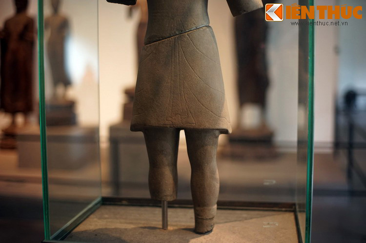 Về trang phục, tượng mặc áo cổ tròn có nếp gấp mềm mại kéo dài xuống đùi.