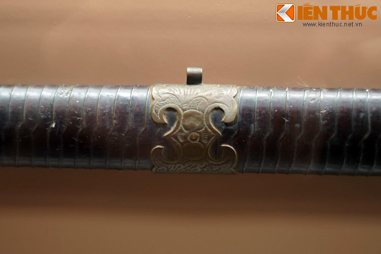 Họa tiết bằng đồng trên vỏ thanh gươm lưỡi thẳng. Không chỉ là vũ khí chiến đấu, gươm còn có thể đóng vai trò của một vật phẩm dùng trong nghi lễ.