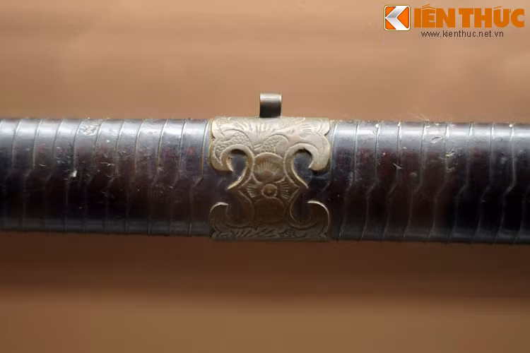 Họa tiết bằng đồng trên vỏ thanh gươm lưỡi thẳng. Không chỉ là vũ khí chiến đấu, gươm còn có thể đóng vai trò của một vật phẩm dùng trong nghi lễ.