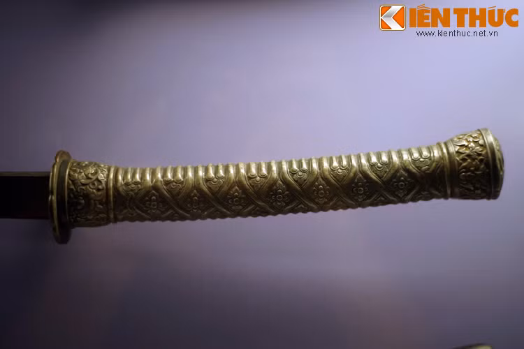 Chuôi thanh kiếm này được bọc đồng toàn bộ với các họa tiết dạng hoa lá. Vào đầu năm 1785, hàng vạn quân Xiêm La đã rầm rộ kéo sang nước ta, theo đường thủy tấn công căn cứ quân Tây Sơn ở Mỹ Tho bằng hàng trăm chiến thuyền lớn.