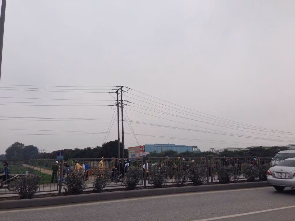 Một số người dân bị lực lượng chức năng chặn lại bên đường đối diện KCN Cẩm Điền - Lương Điền.