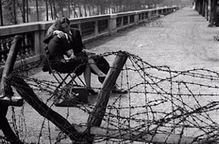 Cặp đôi thể hiện tình cảm trước hàng rào thép gai ở Tuilleries.