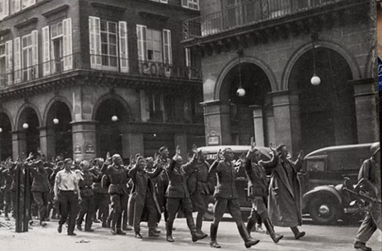 Binh lính phát xít Đức giơ tay đầu hàng, bị quân đồng minh dẫn giải trên đường phố Rue de Castiglione.