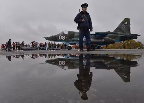 Lính gác tuần tra tại căn cứ không quân Kant của Nga, ở ngoại ô Bishlek của Kyrgyzstan. Hậu cảnh bức ảnh là một chiếc phản lực chiến đấu Su-25.