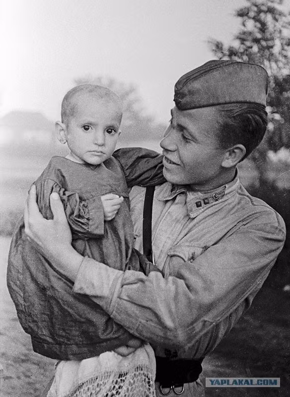Binh sĩ Liên Xô ôm một bé gái được anh cứu sống ở làng Elkhontovo năm 1942.