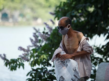 Phanh áo ngồi bên bờ hồ Hoàn Kiếm.