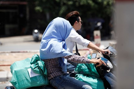 Trùm áo lên đầu khi đi trên phố.