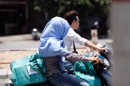 Trùm áo lên đầu khi đi trên phố.