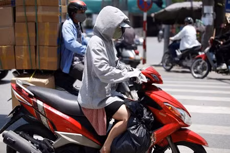 Chị em phụ nữ ra đường bịt kín từ đầu đến chân bằng áo chống nắng.