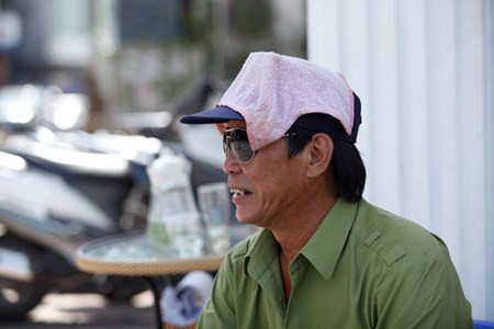 Bác bảo vệ phải dùng khăn mặt thấm nước đội lên đầu.