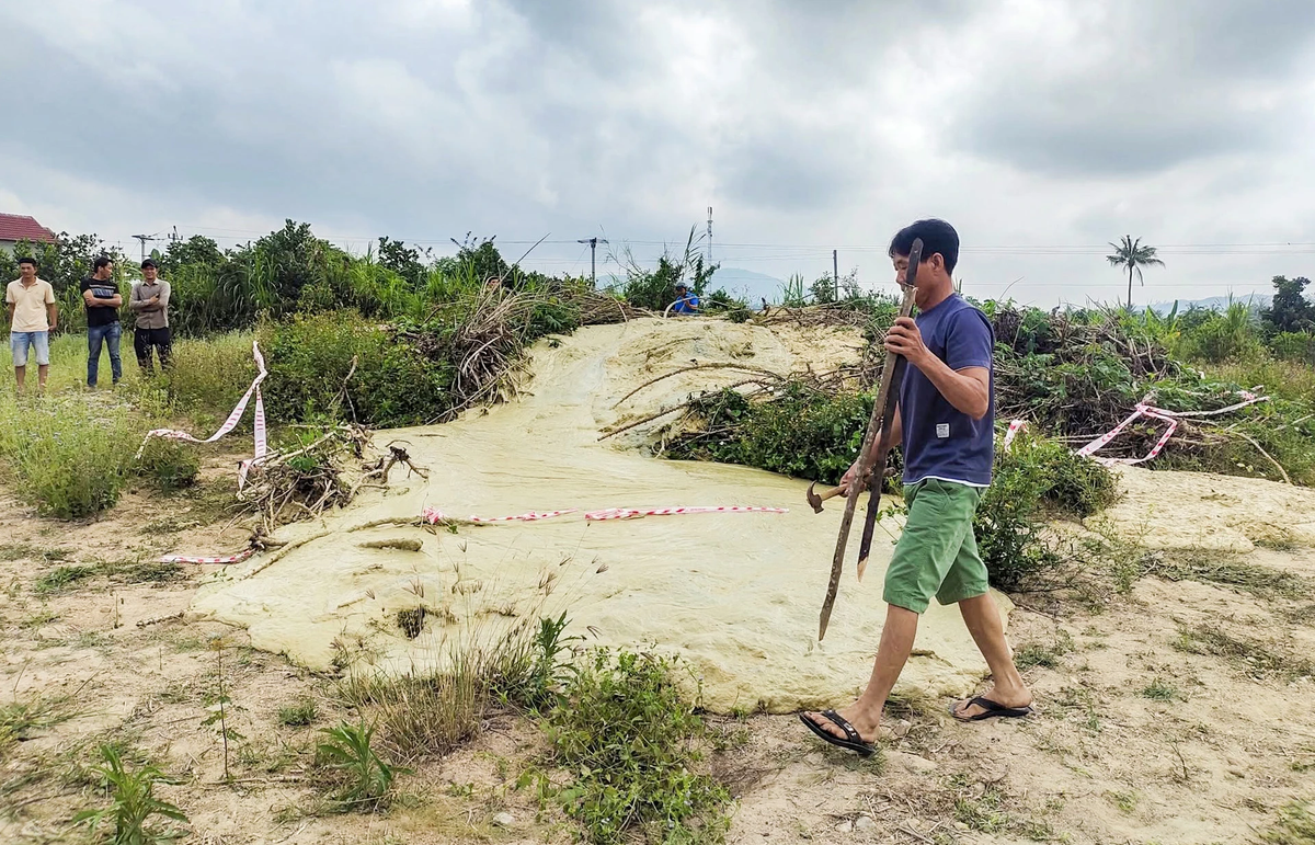 Một người dân hiếu kỳ lấy một khúc tre dài khoảng 8 m để đo độ sâu của miệng hố bùn phun nhưng không chạm đến đáy.