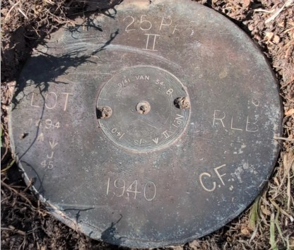 Trong lúc cắt cỏ ở sân sau, một người đàn ông ở Anh phát hiện vật thể lạ nhỏ nằm sâu 2,5cm dưới đất, khắc số "1940" và nhiều ký hiệu. (Ảnh: Express)