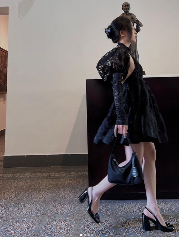 Nữ streamer 9X khoác lên mình chiếc váy đen với thiết kế sang trọng nhưng không kém phần quyến rũ, tạo điểm nhấn bằng tay áo dài bồng cùng ống tay dan lưới.
