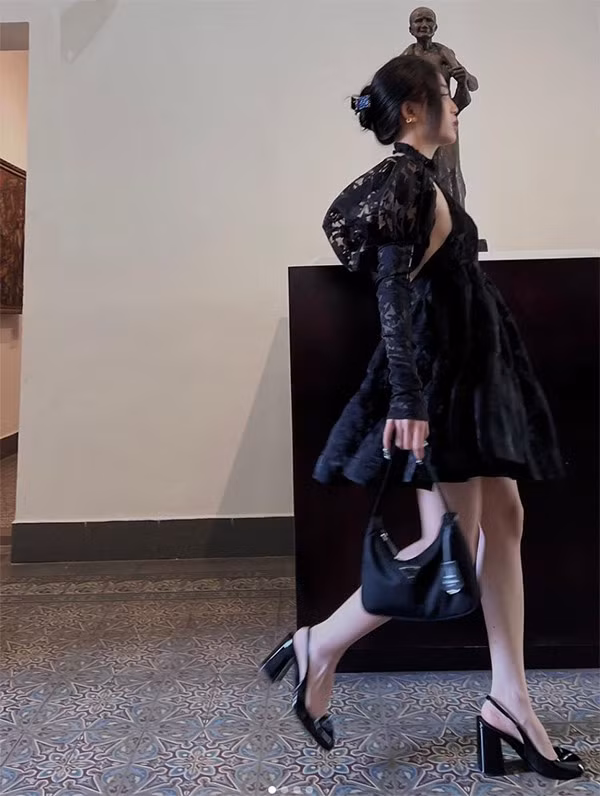 Nữ streamer 9X khoác lên mình chiếc váy đen với thiết kế sang trọng nhưng không kém phần quyến rũ, tạo điểm nhấn bằng tay áo dài bồng cùng ống tay dan lưới.
