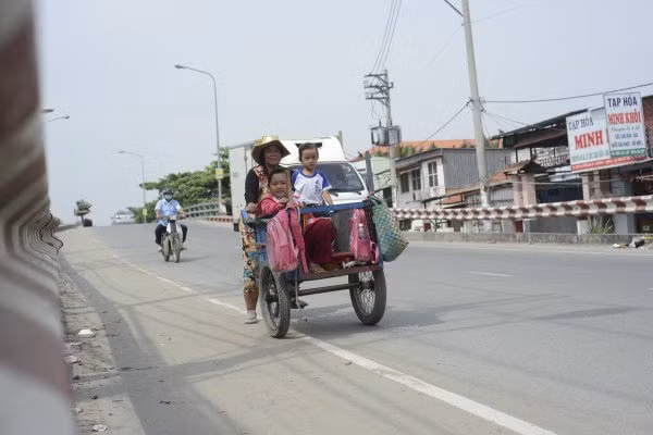 Bà nội 61 tuổi hàng ngày hai lượt đưa - đón các cháu đi học trên chiếc xe ba gác - cũng là phương tiện mưu sinh của mình