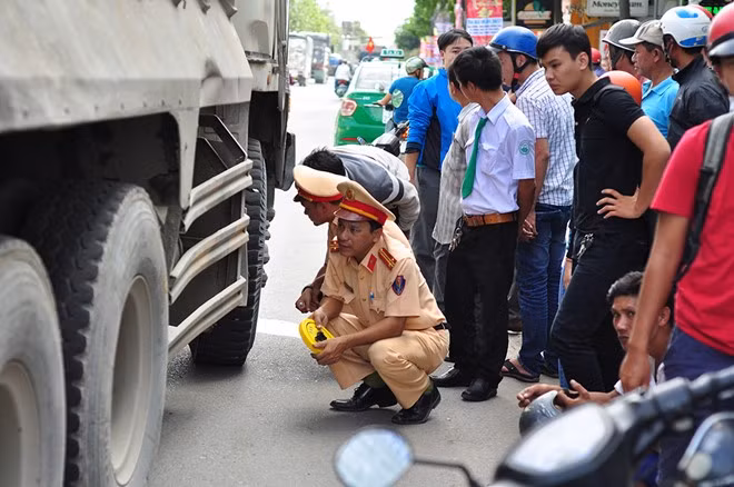 Lực lượng chức năng ghi nhận dấu vết trên bánh xe tải để phục vụ điều tra. Ảnh: Ngọc An.