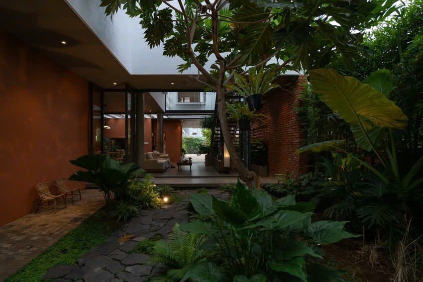 Sân vườn được bố trí xung quanh nhà, xen kẽ trong khoảng sân và giếng trời. Từ đó, các mảng xanh và không gian sử dụng được hòa vào nhau, không có sự ngăn chia giữa trong và ngoài nhà.