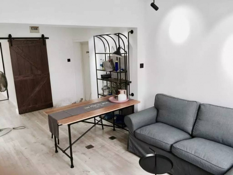 Phòng khách được ngăn cách với lối ra bằng một chiếc bàn đơn giản trông rất thuận mắt.