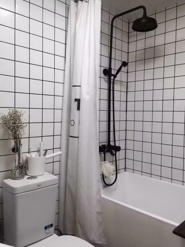 Thay đổi tiếp theo là phòng tắm, gạch men màu trắng cũ bẩn đã được thay mới hoàn toàn cùng với những đường kẻ màu đen, tạo ra không gian mới vừa hiện đại vừa mới mẻ. Phòng tắm cũng chỉ có vài mét vuông nhưng vẫn đủ để đặt một bồn tắm riêng biệt.