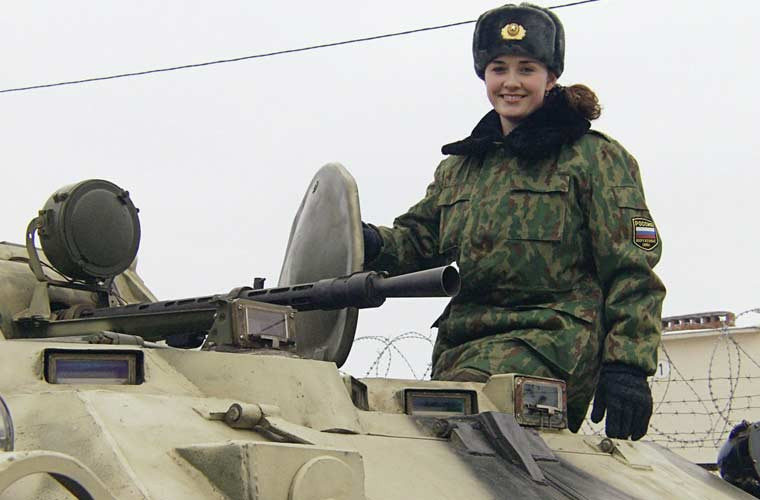 Một nữ quân nhân xinh đẹp cười tươi trên xe thiết giáp chở quân BTR-80.