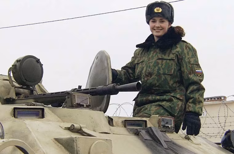 Một nữ quân nhân xinh đẹp cười tươi trên xe thiết giáp chở quân BTR-80.