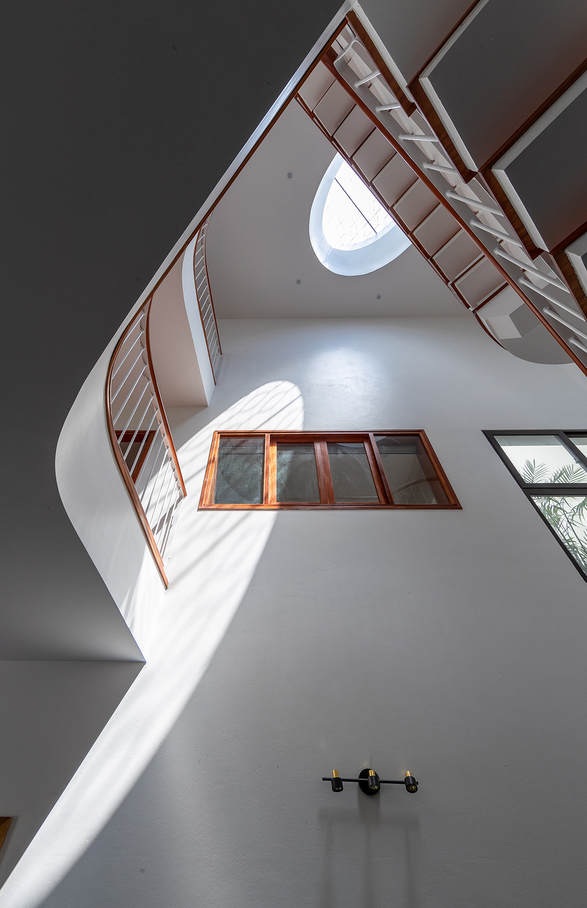 Một góc vườn giếng trời hình tam giác được tạo ra liên thông với khu vực bếp ăn ở tầng 1. Khu vườn có thể được tiếp cận thông qua một hành lang đệm hẹp dài mà không cần đi vào căn nhà.