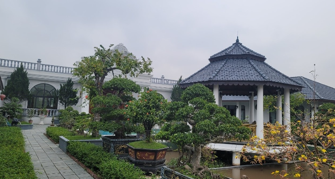 Căn nhà chính màu trắng ở giữa rộng hơn 500m2, có 2 tầng trong đó tầng trên là nhà gỗ để thờ tự. Ảnh: Người đưa tin