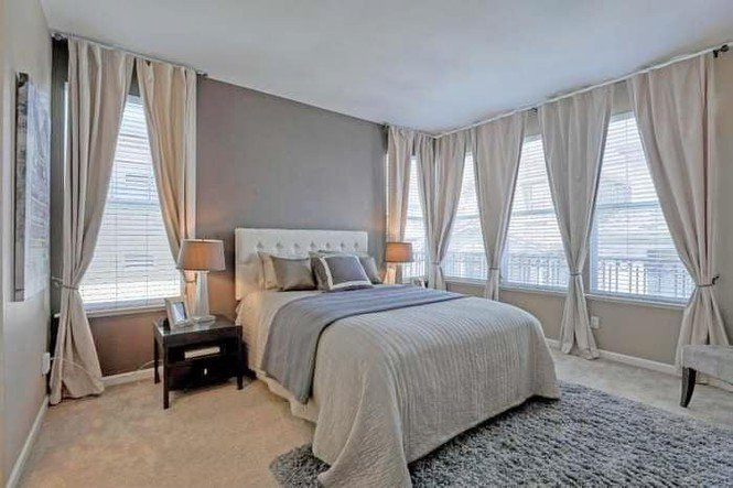 Phòng ngủ ngập ánh sáng nhờ hệ cửa kính cao rộng.