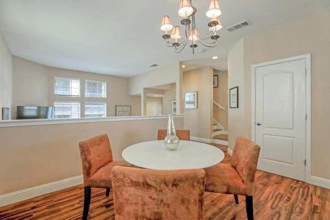 Phòng ăn ấm cúng với bàn tròn màu trắng, ghế sofa bọc nhung màu cam.