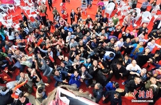 Bất chấp giá lạnh, vị đại gia vẫn hào hứng cởi trần, đứng trên giàn giá cao hơn 100m mà rải bao lì xì xuống. Ảnh: Chinanews