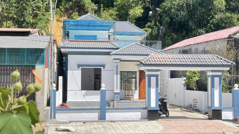 Căn nhà của Lê Thị Dần có tông trắng xanh chủ đạo với 2 tầng lầu cùng cổng ngõ được xây dựng kiên cố.