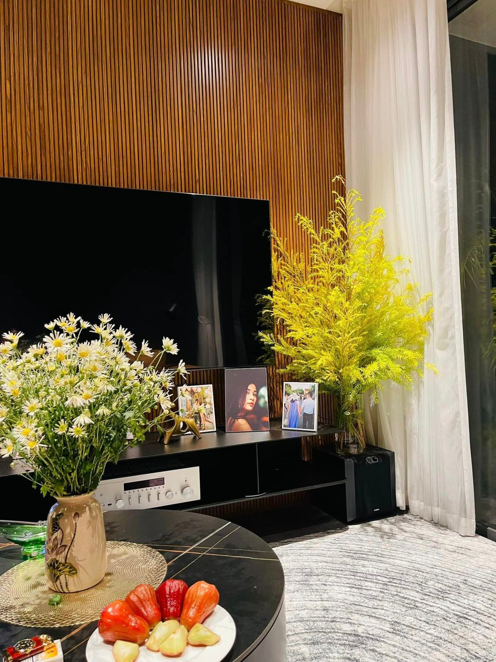 Minh Hương còn đặt một chiếc bàn nhỏ màu đen, có tông màu tương tự phần kệ tivi, sơn tường.