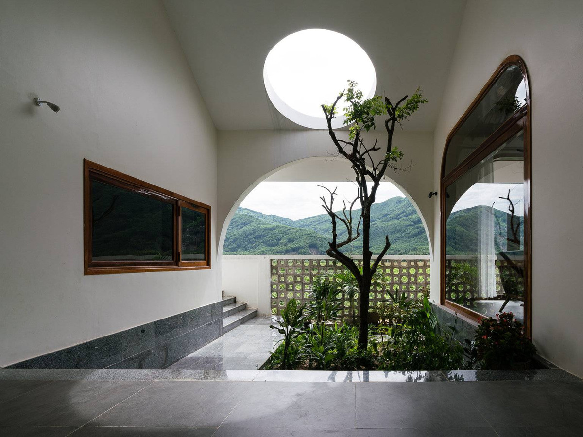 Khu vườn nhỏ tại hành lang cung cấp ánh sáng và luồng gió mát lành thông qua cây thân gỗ.