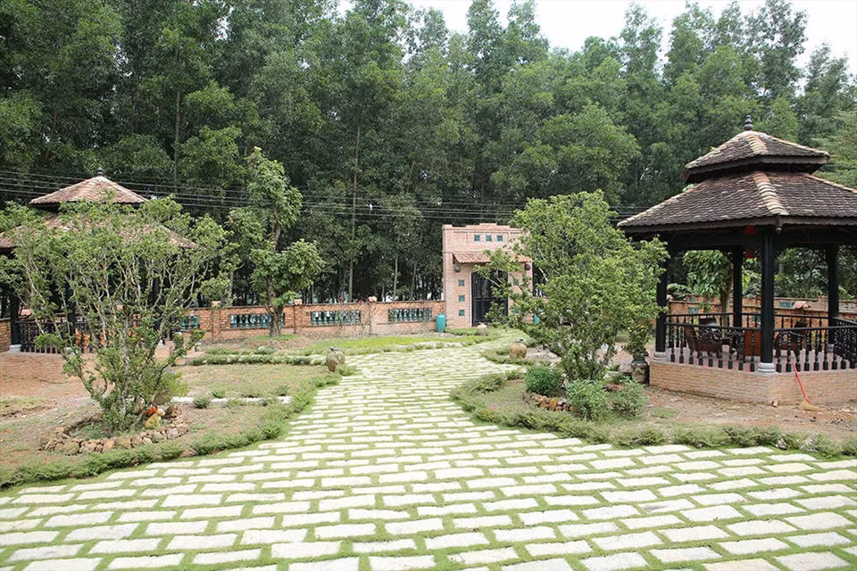 Biệt phủ được bao quanh bởi những hàng cây xanh mướt và tưởng gạch đỏ rêu phong. Ảnh: Lao động