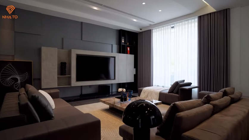 Phòng khách sử dụng tông màu nâu, đen chủ đạo, điểm xuyết là gam màu trắng giúp không gian thêm hài hoà.