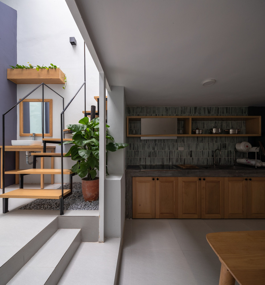 Nâng mái mới cao hơn tạo khoảng trống và giúp thông gió. Sân trước, sân sau và khoảng đệm giữa nhà giúp ánh sáng tự nhiên tràn ngập mọi góc.