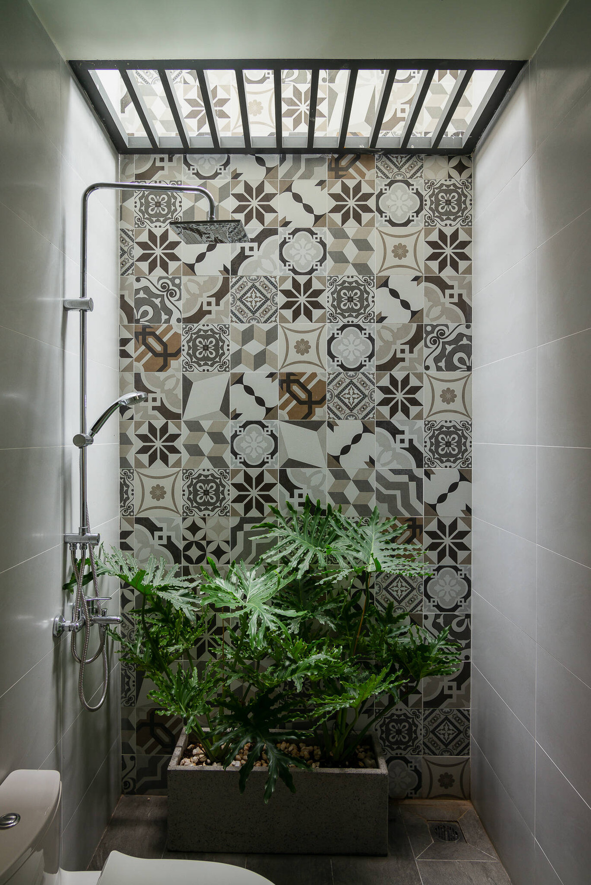 Phòng vệ sinh thoáng sáng với gạch ốp tường hoa văn đẹp mắt cùng cây xanh điều hoà không khí.