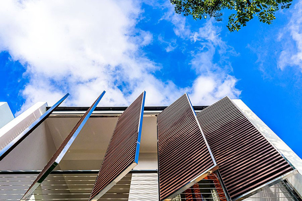 Mặt tiền hướng Tây được xử lý bằng hệ lam đóng mở giúp chắn nắng và thông gió hiệu quả.