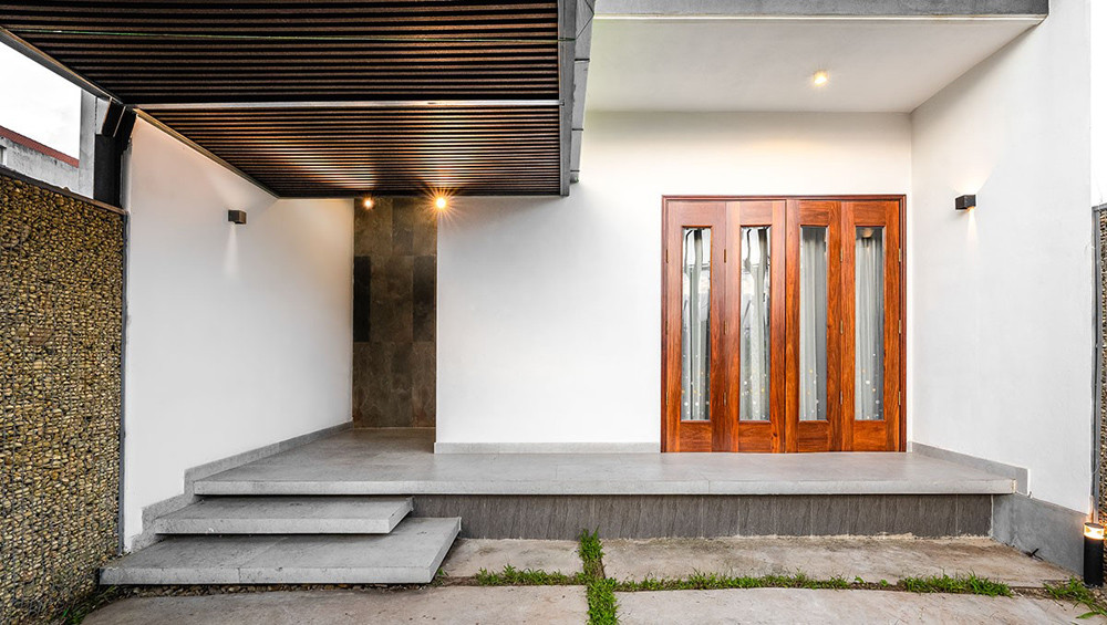 Lối vào nhà với mái hiên sâu tạo không gian đệm giúp cân bằng nhiệt, mát trong mùa hè và ấm vào mùa đông.