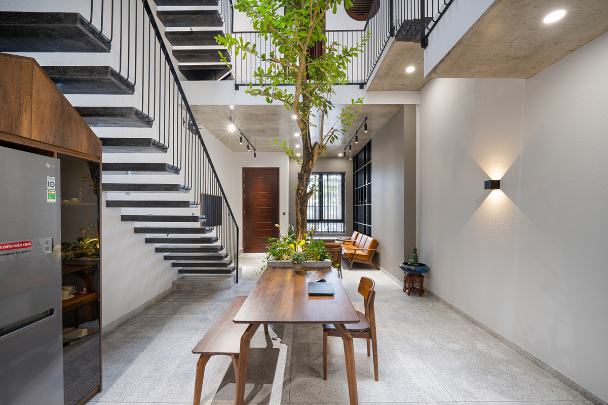 Do đó, kiến trúc sư chọn khu vực bàn ăn làm trung tâm. Bàn ăn được đặt ở vị trí giữa căn nhà và bên dưới ô thông tầng, thể hiện tính kết nối cao.