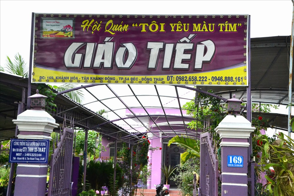 Biển hiệu phía trước căn nhà cũng rực rỡ màu tím. Ảnh: Lao động