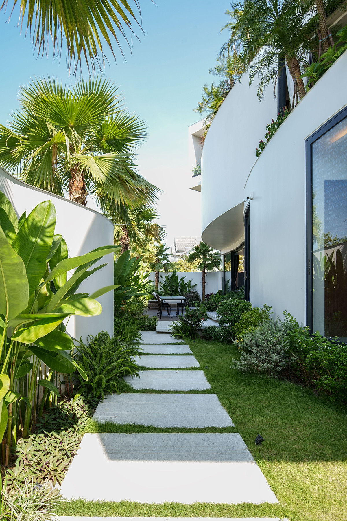 Để tránh ảnh hưởng trực tiếp bởi các luồng khí nóng trong mùa hè đồng thời giảm diện tích bê tông hoá, bao quanh nhà là khoảng sân nhiều cây xanh.